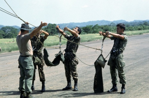 Army special forces soldier instructing columbian parachuters