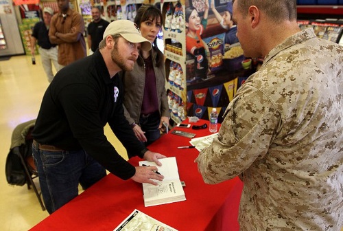 Chris Kyle signing a copy of his book - American Sniper