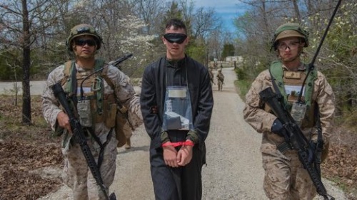 marine military police escort a mock prisoner