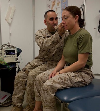 navy doctor exams a marine patient