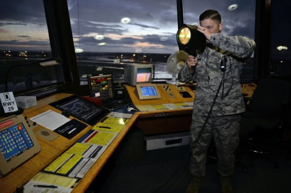 Air Force air traffic controller uses a light gun to transmit messages to pilots