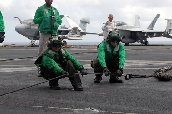 green shirts on an aircraft carrier