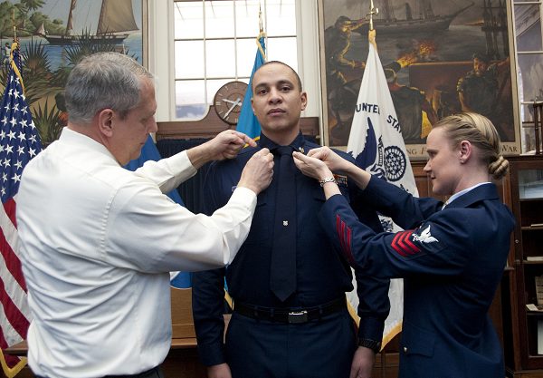 Coast Guard Servicemen pin second class crows on U.S. Coast Guard Petty Officer 2nd Class