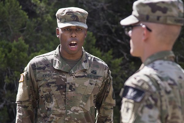 Army drill instructor gives a soldier commands on the situational training exercise lanes