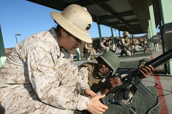 combat marksmanship coach helps a Marine find his settings for teh USMC rifle qualification 