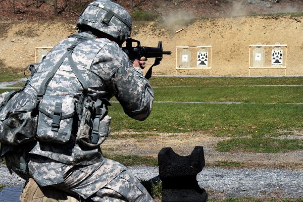 soldier fires an M16 rifle from the kneeling position during the army rifle qualification