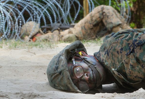 Marine recruit crawling through the sand during the crucible at Parris Island